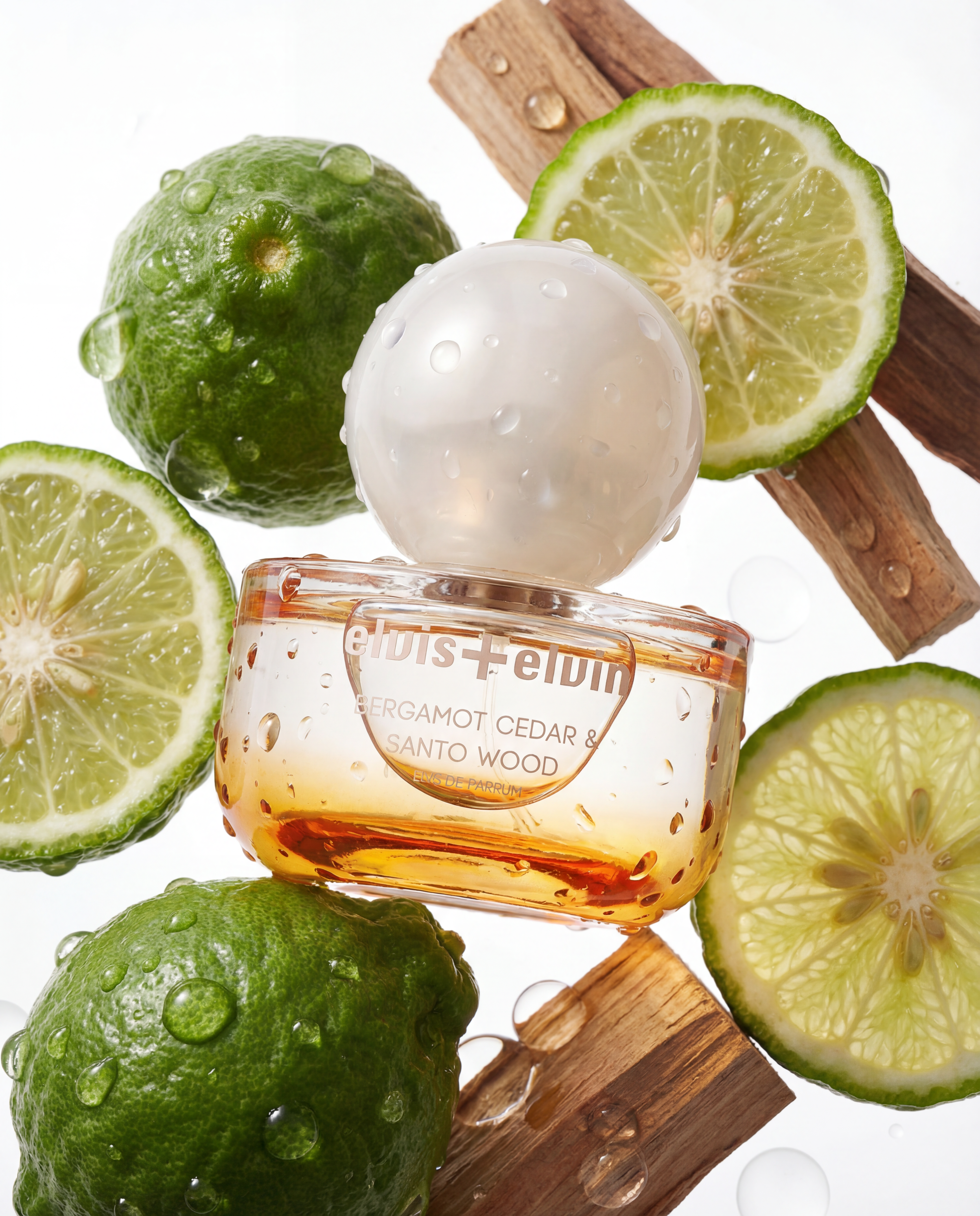 elvis+elvin Bergamot Cedar & Santo Wood, Perfume bottle with green fruits and wood elements on a white background